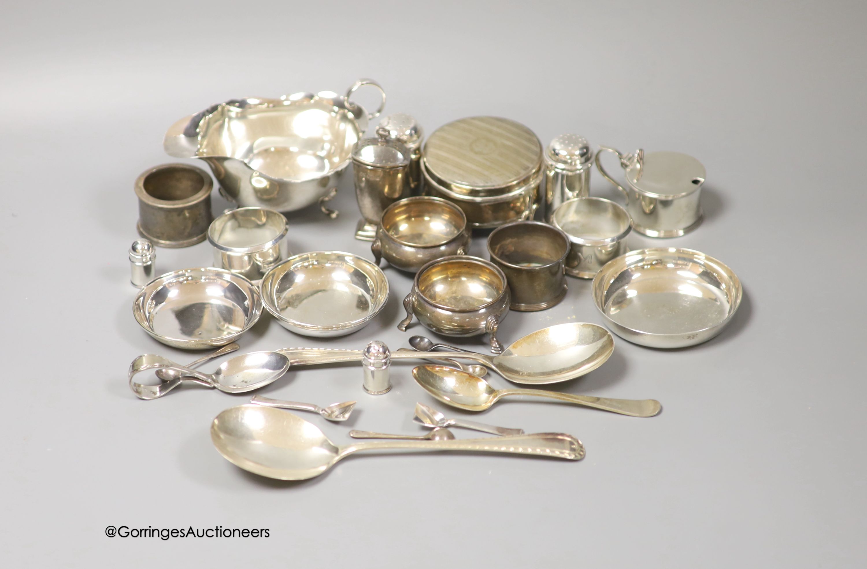A group of minor silver including a George V trinket box, sauceboat, pair of soup spoons, pair of napkin rings, two bun salts, four small dishes, condiments etc. and three plated items.